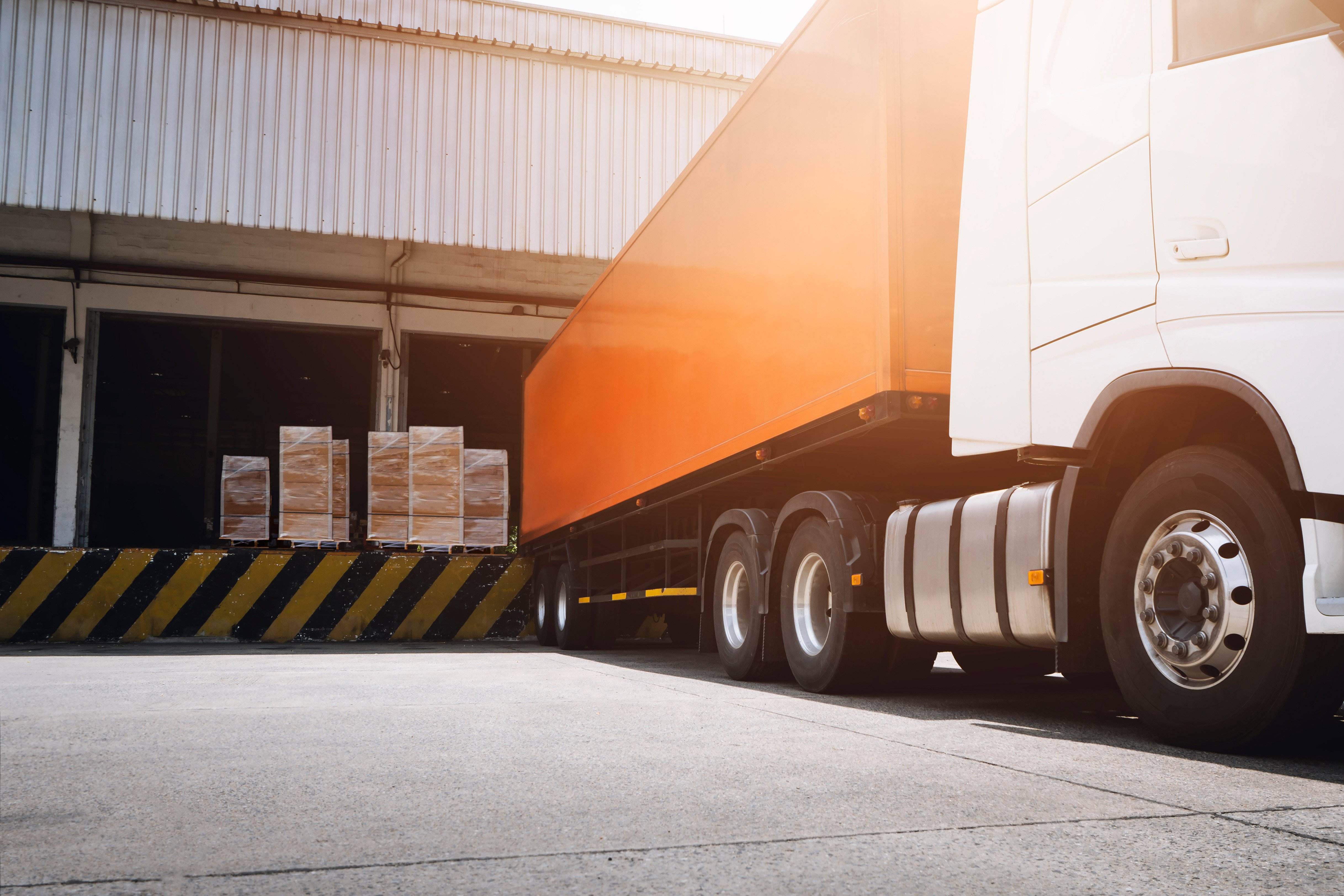 Orange truck being loaded with boxes for carrier shipping